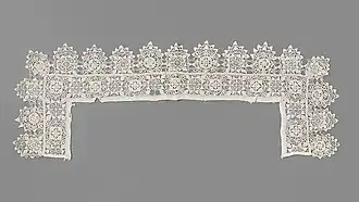 Collet carré et incliné en point coupé et reticella. Le col est festonné.