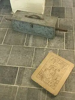 Pierre lithographique et rouleau encreur dans sa boîte protectrice.