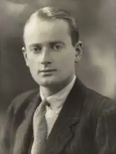 Photographie en noir et blanc et en buste d'un homme vêtu d'un costume.