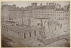 Photographie ancienne en noir et blanc montrant le palais de la Bourse en construction.