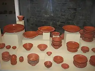 Photographie en couleurs d'une vitrine d'exposition avec des ustensiles en céramique.