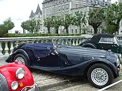 Photographie en couleurs d'une exposition d'anciennes voitures sportives.