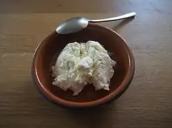 Photographie d'un fromage frais dans un récipient.