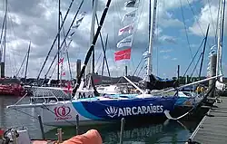 Vu de trois quarts face, foiler bleu et blanc amarré au ponton.