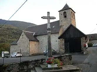 Une croix monumentale avec en arrière-plan, l'église Saint-Michel