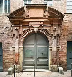 Comère : portail à carrosses en brique taillée, ouvrant sur la cour.