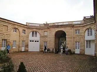 Porte cochère et dépendances depuis la cour. À gauche se trouvait l'écurie, et à droite la remise pour les carrosses.
