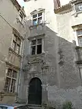 Angle d'une cour de bâtisse Renaissance&nbsp;: fenêtres à meneau et porte d'entrée ornée de pilastres et fronton.