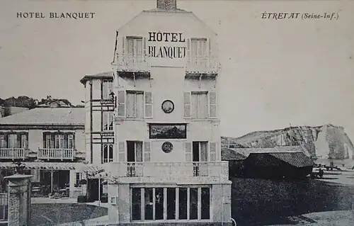 L'hôtel Blanquet à Étretat vers 1890 avec l'enseigne d'Eugène Lepoittevin sur sa façade. Carte postale (début du XXe&nbsp;siècle).