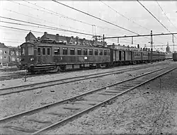 Composition avec un fourgon en bois à essieux (1946).