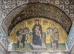 Vue d'une mosaïque représentant deux hommes couronnés entourant une femme portant dans ses bras un enfant