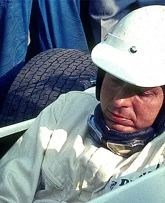 Photo de Hubert Hahne dans le cockpit d'une monoplace, vêtu de blanc, casqué, visage découvert.