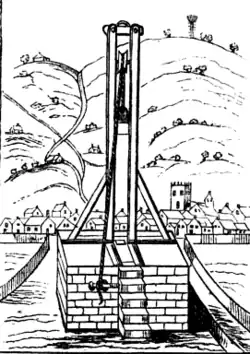 Un dessin en noir et blanc représentant une guillotine, avec ses cordes et leviers, dans un paysage stylisé comprenant collines, vallée et village, mettant l'accent sur la fonction mécanique de l'engin.