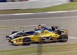 Photo d'une monoplace bleue en train de dépasser une monoplace jaune, en piste