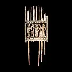 Centre : rectangle ajouré montrant 2 femmes & 1 homme. Inscription visible sur les bords de la plaque.