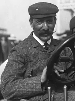 Photo en portrait de Henri Cissac prenant la pose au volant.