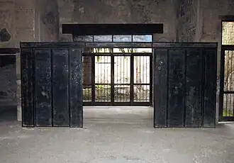 grande pièce divisée par deux pans de cloison sombre