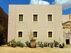 photographie couleurs : un bâtiment jaune avec six fenêtres