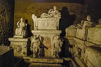 Hypogeum Voluminis de « Perugia » décorant la crypte funéraire du hiérarque étrusque « Arnth Velimna ». Triptyque sculpté en pierre d'arenaria attribué à la fin IIIe&nbsp;siècle&nbsp;av. J.-C. et début du IIe&nbsp;siècle&nbsp;av. J.-C..