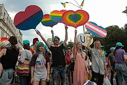 Photograph of a crowd holding heart shaped flags representing various LGBTIQ communities