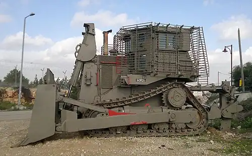 D9R/T (blindé de quatrième génération) de Tsahal stationné près d'un avant-poste militaire (vue de côté).