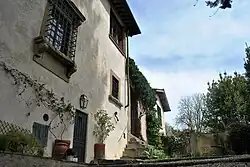 Photo couleurs d'une demeure ancienneavec des barreaux cloisonnés à la fenêtre et des fleurs