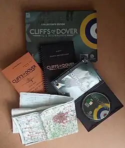 Un coffret sombre avec des boîtes, livrets et cartes sortis devant.
