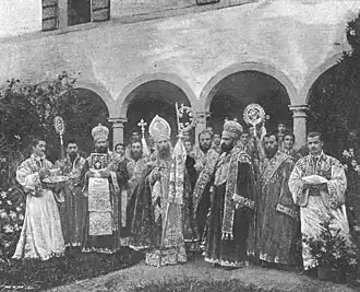 Photographie en noir et blanc d'un groupe de moines posant dans un cloître.