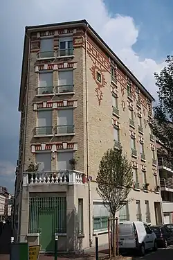 Immeuble en briques rouges au croisement avec la rue Curie.