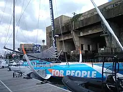 Voilier bleu et blanc amarré au ponton.