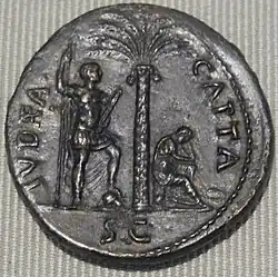 Pièce de 71 : Vespasien avec une lance et un parazonium, le pied sur un casque ; à droite, la Judée en pleurs.