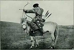 Photo noir et blanc d'un archer à cheval.