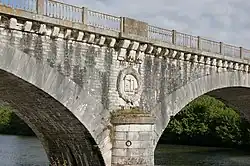 Pile d’un pont en arc en pierre portant les lettres «&nbsp;E D&nbsp;» entourées d’une couronne de lauriers.