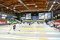 Intérieur du palais des sports avec escrimeurs à l'entraînement