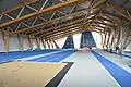 Intérieur du pôle d'athlétisme, avec pistes et terrain sableux au premier plan