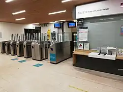 Intérieur du bâtiment voyageurs, guichet et lignes de contrôle.