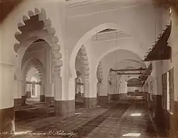 Intérieur d'une mosquée ancienne, avec de nombreuses colonnes.
