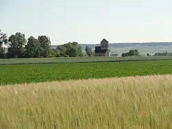 L'église des Istres, entourée de champs, avec en arrière-plan la côte des blancs.