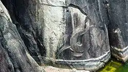 Au-dessus de l'eau, la tête d'un éléphant en léger bas-relief lève sa trompe finement sculptée.