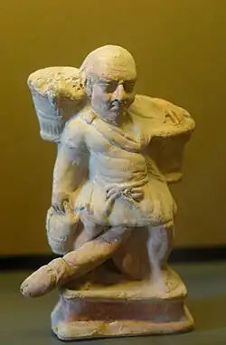 Esclave nain ithyphallique portant deux paniers. Terre cuite, Myrina (Mysie), (Ier siècle av. J.-C.).