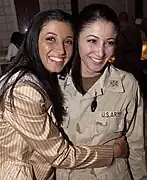 Miss New York USA 2004, Jaclyn Nesheiwat&nbsp;(en) (à gauche) rend visite aux troupes américaines en Irak en mars 2004. À Bagdad, elle rencontre sa sœur, le capitaine Julie Nesheiwat (à droite).