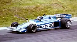 Photo d'une monoplace bleue et blanche en piste, vue de côté gauche.