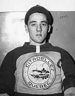 Portrait-photo de Jacques Plante portant un bonnet sur la tête et un maillot de hockey.