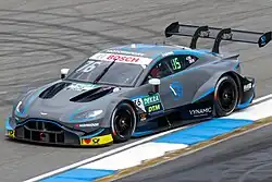 Photographie d'une voiture de tourisme grise et bleue, vue de trois-quarts gauche, sur une piste sèche.