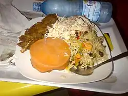 Riz frit nigérian accompagné de poisson, d’une salade et d’un pudding de haricots cuits à la vapeur.
