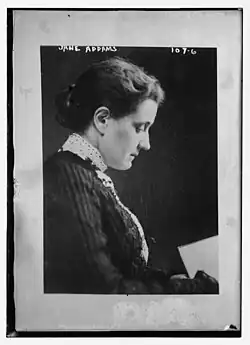 Portait photographique noir et blanc d'une femme blanche de profil portant un chignon et lisant un livre