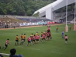 Deux équipes lors d'une remise en touche, un joueur en l'air s'apprêtant à recevoir le ballon.