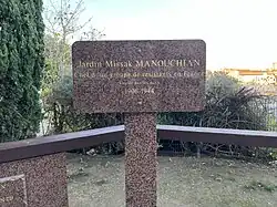 Photographie du panneau du jardin Missak Manouchian de Marseille disant « Chef d'un groupe de résistants en France. Fusillé par les nazis. 1906-1944 ».