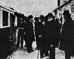 Photographie en noir et blanc d'un groupe d'homme discutant à côté de l'autorail Pauline, Jean-Raoul Paul porte un chapeau et une barbe blanche.