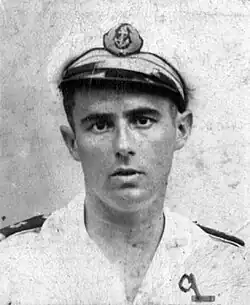 Officier de marine en tenue blanche, la casquette de travers, avec les deux galons d'enseigne de vaisseau de première classe